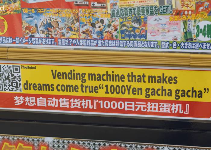 A random prize vending machine with a label that says, "Vending machine that makes dreams come true."